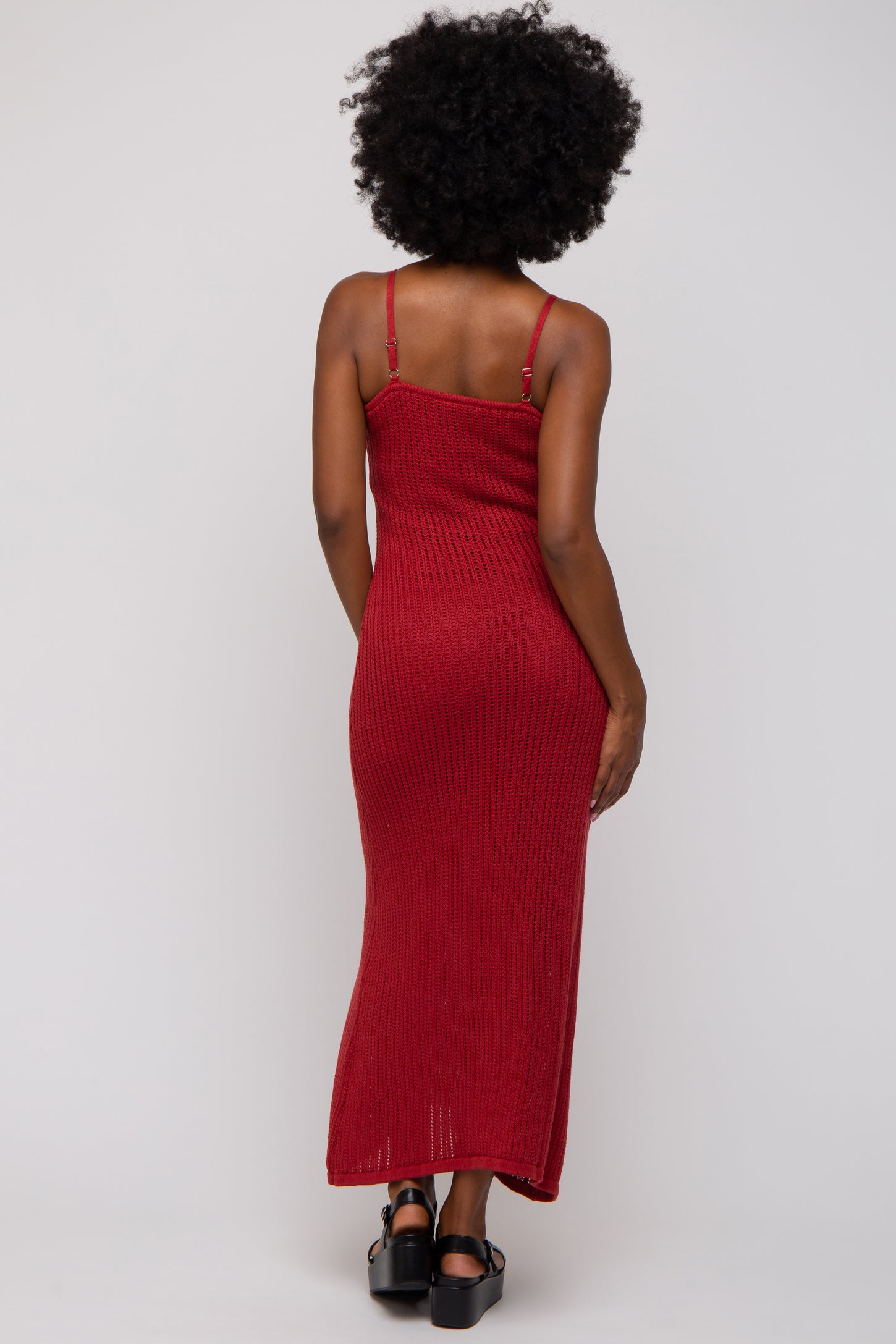 woman wearing a red ribbed maxi dress with thin straps, view from the back