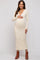 woman wearing a beige ribbed maternity dress with long sleeves and a v-neck, holding her baby bump