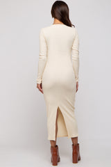 woman wearing a cream long sleeve ribbed maternity dress with a slit at the back