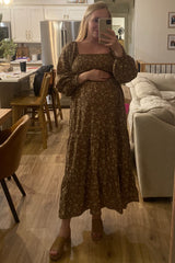 woman wearing a brown floral maternity dress with long sleeves and a baby bump, standing in a mirror selfie