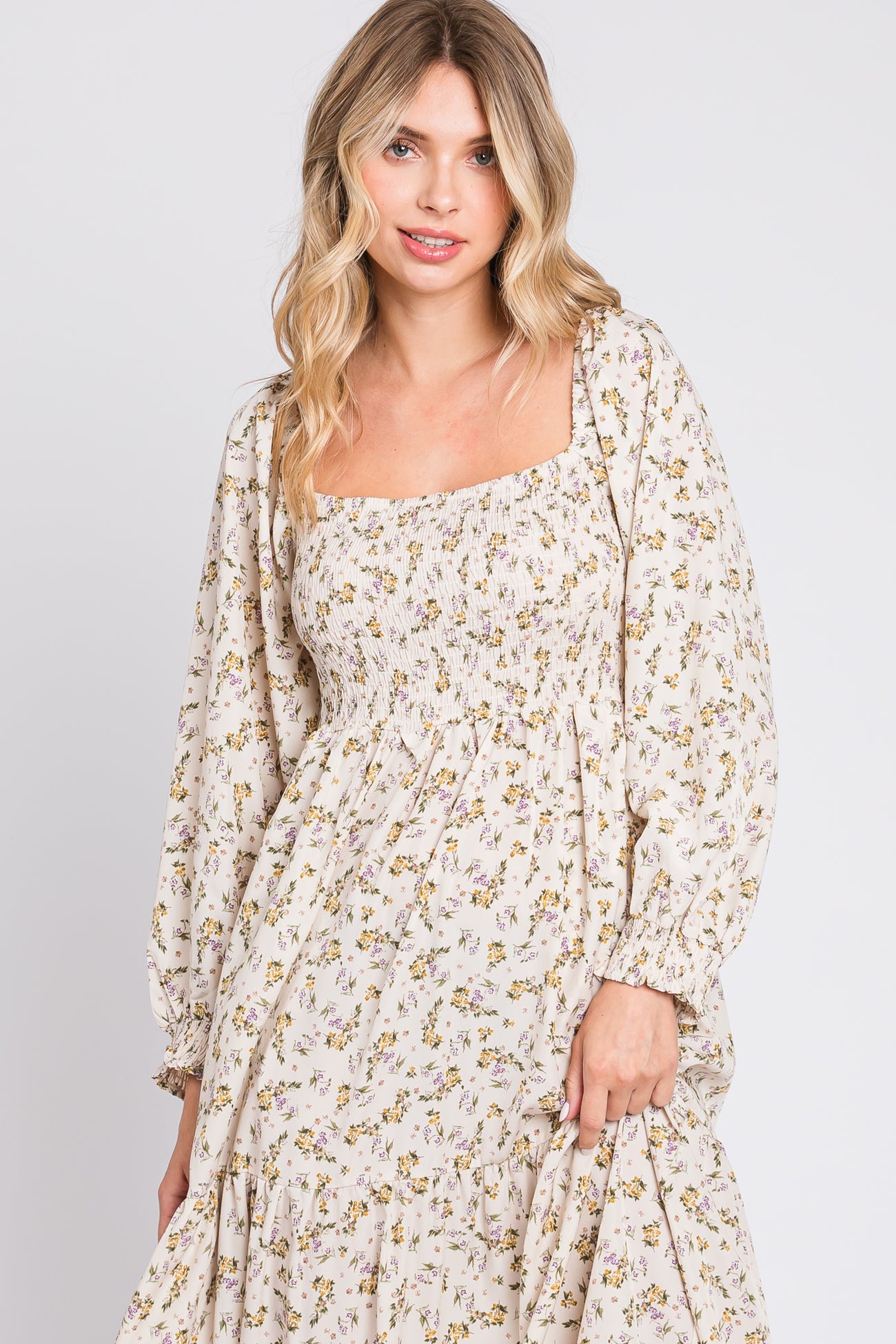 woman wearing a cream floral maxi dress with a square neckline and long puff sleeves