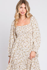 woman wearing a cream floral maxi dress with a square neckline and long puff sleeves