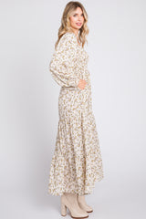 woman wearing a long sleeve floral print maxi dress with a tiered skirt and pockets, paired with beige ankle boots