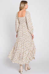 woman wearing a long floral maxi dress with puffed sleeves and a square neckline, showing the back view