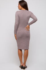 woman wearing a mauve long sleeve fitted maternity dress, showing the back view