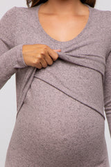 woman wearing a mauve long sleeve maternity top with a ruching detail and holding her baby bump