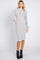 woman wearing a grey ribbed long sleeve midi dress and black ankle boots
