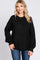 woman wearing a black oversized sweater with long sleeves and a ribbed hem, smiling at the camera