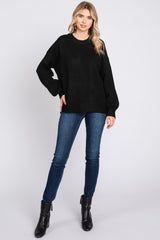 woman wearing a black oversized sweater with dropped shoulders and paired with skinny jeans and ankle boots
