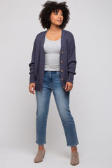 woman wearing a grey tank top, navy cardigan, and light blue jeans with beige mules
