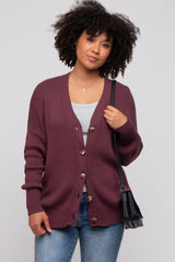 woman wearing a burgundy ribbed cardigan with buttons, styled with a gray tank top and casual jeans, holding a small black handbag