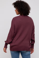woman wearing a maroon oversized sweater with a relaxed fit and dropped shoulders, seen from the back
