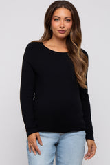 woman wearing a black long sleeve maternity top and jeans, showing her baby bump