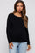 woman wearing a black long sleeve maternity top and jeans, showing her baby bump