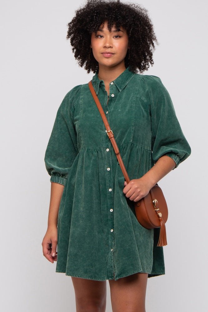woman wearing a green denim shirt dress with puff sleeves and button detailing, holding a brown crossbody bag