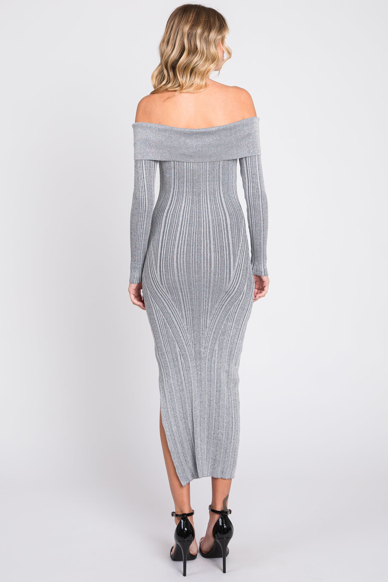 woman wearing a grey off-the-shoulder fitted maxi dress with ribbed detailing and side slit, viewed from the back