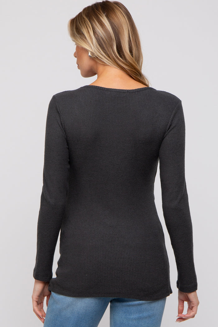 woman wearing a dark gray ribbed maternity top, showing the back view, paired with blue jeans
