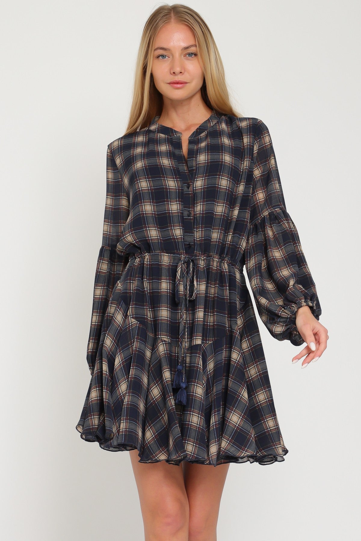 woman wearing a navy plaid long sleeve dress with a drawstring waist and flared skirt