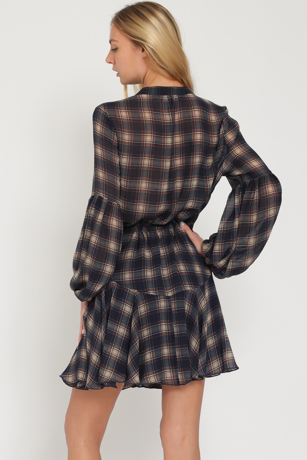 woman wearing a navy plaid long sleeve dress with a fitted waist and flared skirt, shown from the back