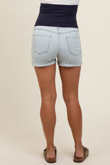 woman wearing light wash maternity shorts with a navy blue stretchy waistband from the back