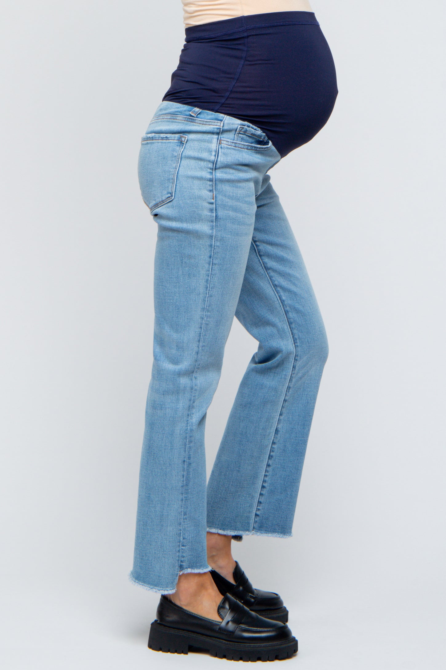 maternity wear light blue flared jeans with a navy waistband, model showing baby bump from the side