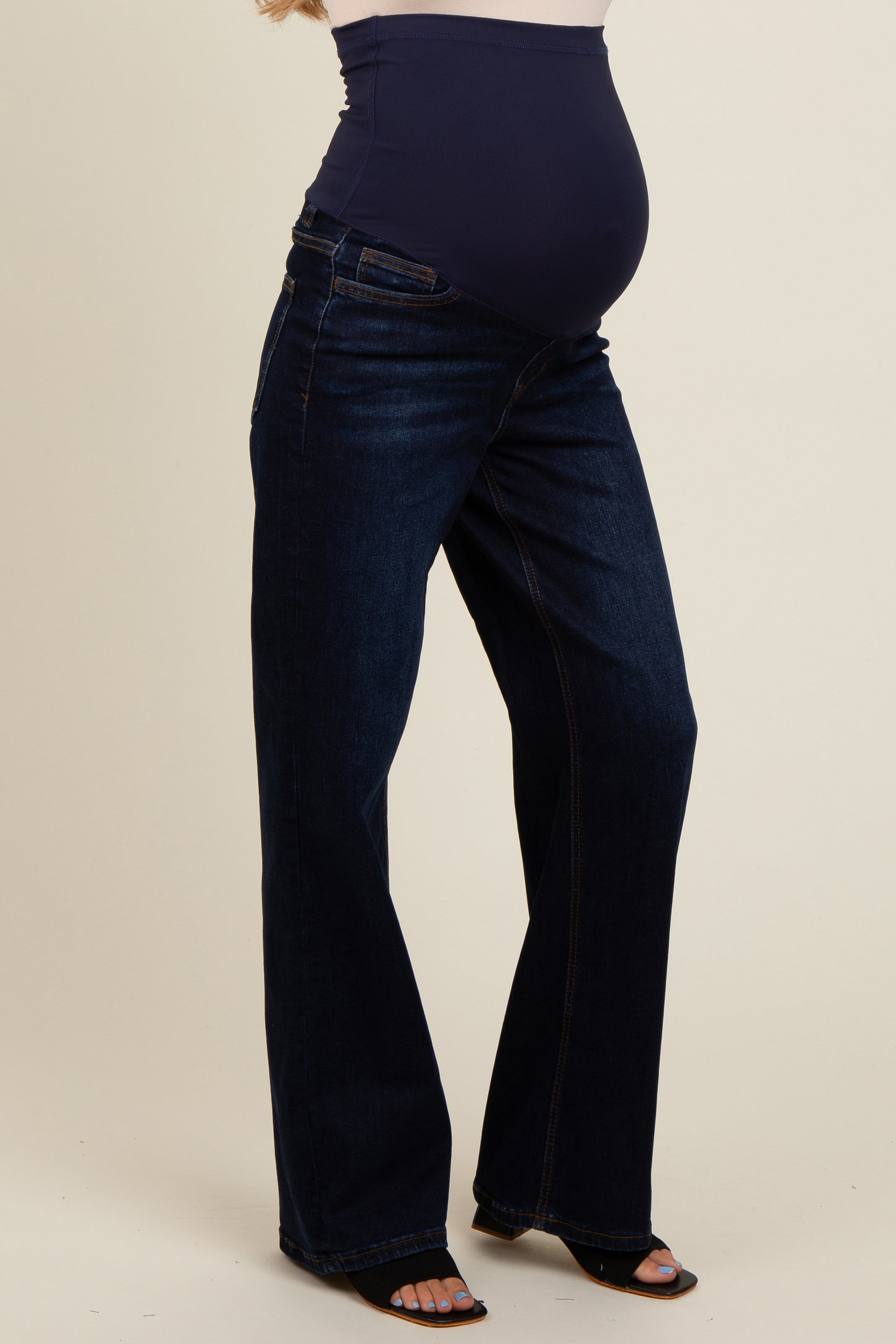 maternity wear dark blue wide leg jeans featuring a supportive belly panel, model showing a visible baby bump