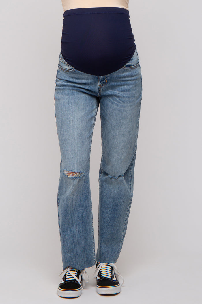 woman wearing a pair of light blue maternity jeans with a dark blue belly panel and distressed details on the front