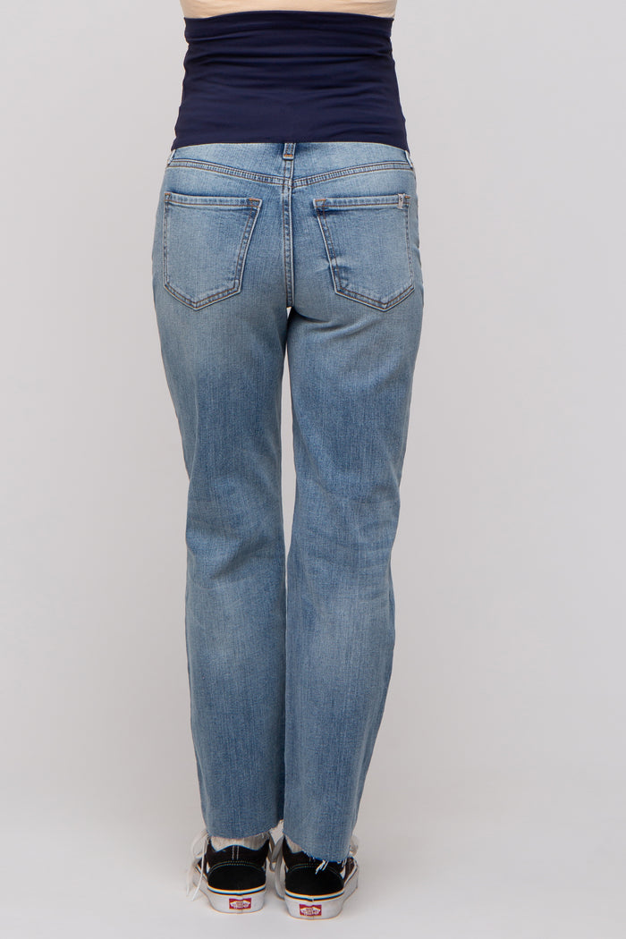 woman wearing light blue maternity jeans with a frayed hem, shown from the back