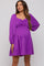 woman wearing a purple maternity dress with long puff sleeves and a ruched bodice accentuating her baby bump