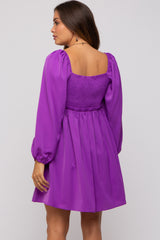 woman wearing a purple maternity dress with a smocked bodice and puffed sleeves, viewed from the back