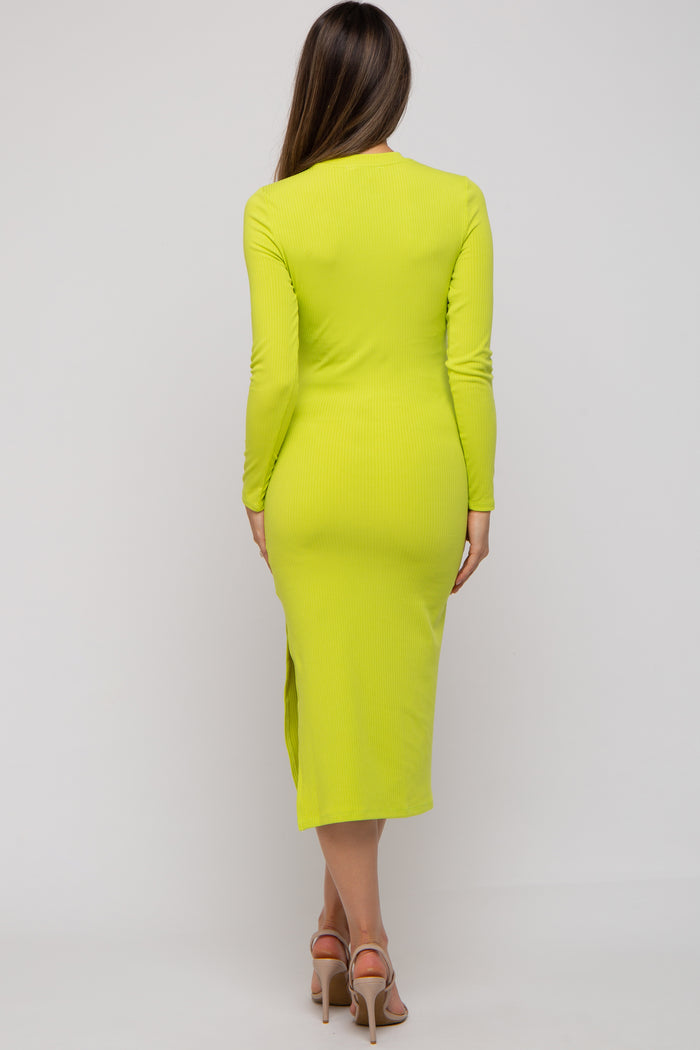 woman wearing a bright yellow long sleeve maternity dress with a knee-high side slit