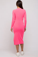 woman wearing a bright pink long sleeve maternity dress with a fitted silhouette and midi length