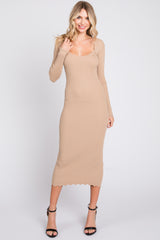 woman wearing a fitted beige ribbed midi dress with long sleeves and a scalloped neckline