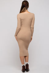 woman wearing a beige ribbed midi maternity dress with long sleeves and scalloped hem, showing her baby bump from the back