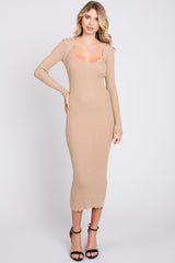 woman wearing a beige ribbed long sleeve midi dress with a scalloped neckline and hemline