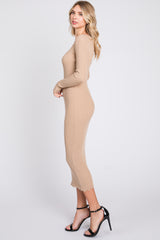 woman wearing a beige ribbed midi dress with long sleeves and scalloped hem, paired with black strappy heels