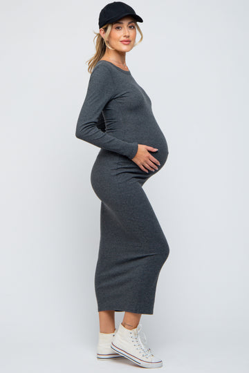 woman wearing a gray long sleeve maternity dress showing her baby bump, styled with a black cap and white sneakers