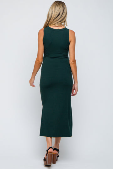 woman wearing a dark green sleeveless maternity dress, shown from the back