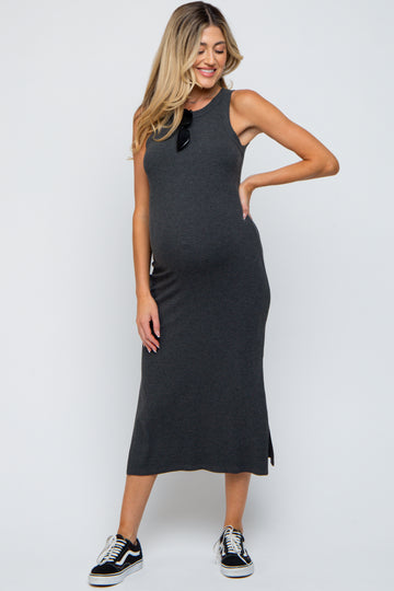 woman wearing a dark gray maternity maxi dress with a side slit and black sneakers, highlighting her baby bump