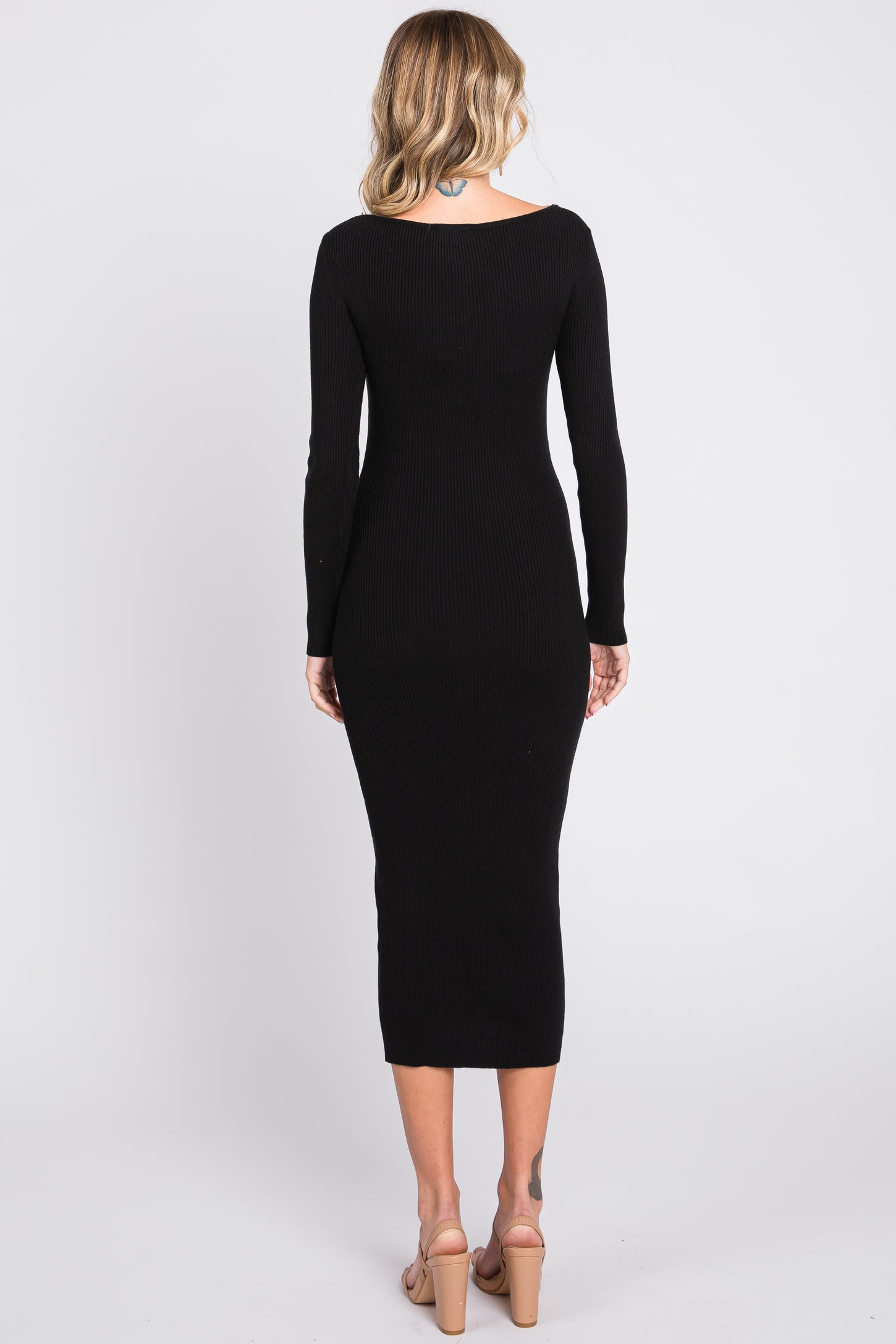 woman wearing a fitted black ribbed long sleeve midi dress, view from the back