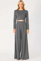 woman wearing a grey long sleeve cropped top and matching wide-leg pants