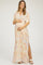 woman wearing a colorful patterned maternity maxi dress and holding her baby bump
