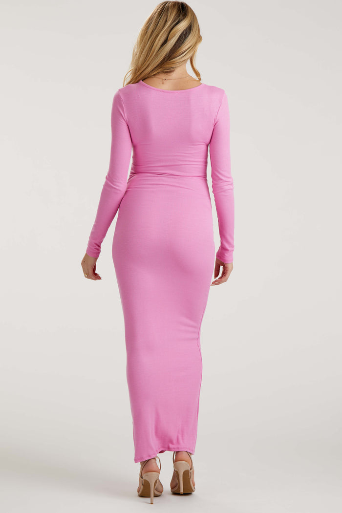 woman wearing a long pink ribbed maternity dress with a fitted silhouette, showing a baby bump from the back