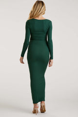 woman wearing a fitted green long sleeve maternity dress, showcasing a baby bump from the back