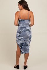 woman wearing a blue and gray floral print maternity dress with adjustable straps and a side slit, showing off a baby bump