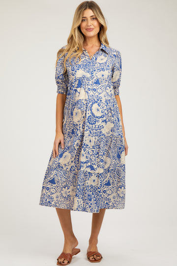 woman wearing a blue and cream patterned maternity dress with short puff sleeves and a midi length
