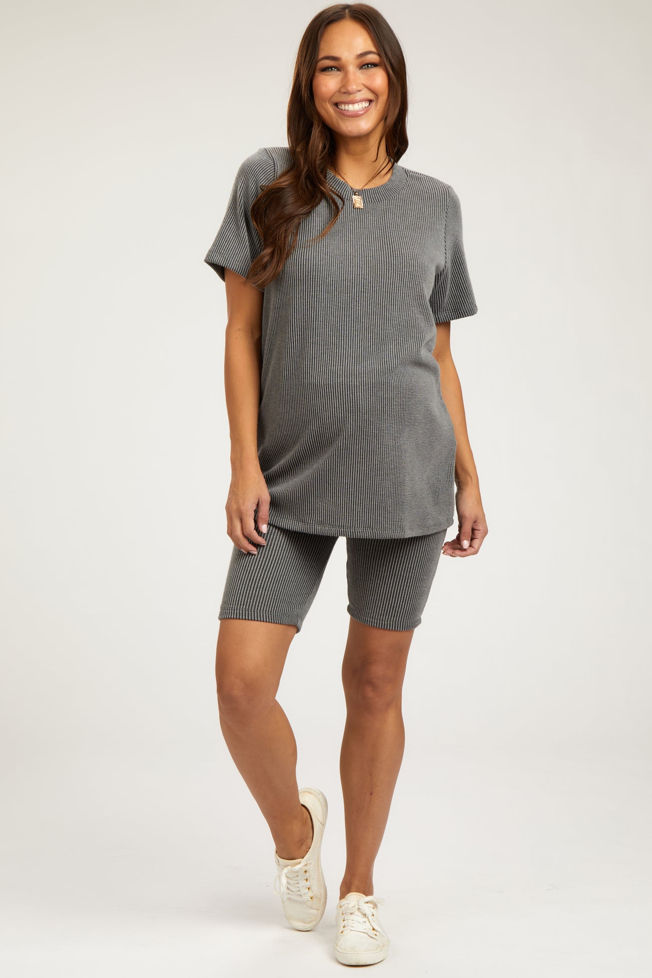 woman wearing a grey ribbed maternity top and matching shorts, showcasing a baby bump