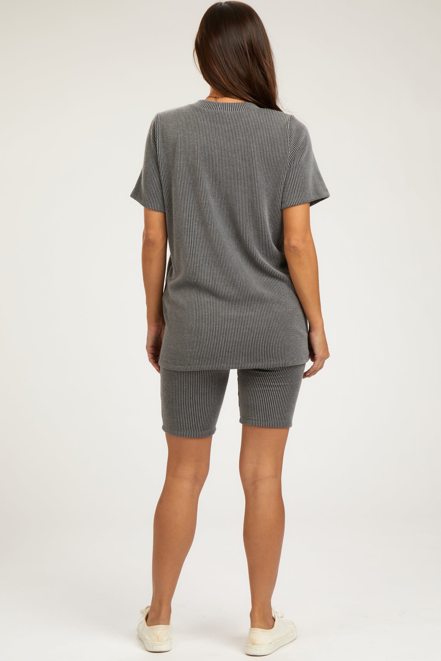 woman wearing a gray maternity shorts set with a loose-fit t-shirt and shorts, viewed from the back