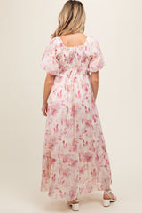 woman wearing a floral maxi maternity dress with puff sleeves and a smocked back, showcasing a baby bump