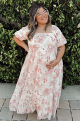 woman wearing a floral printed maternity maxi dress with short sleeves and a baby bump visible